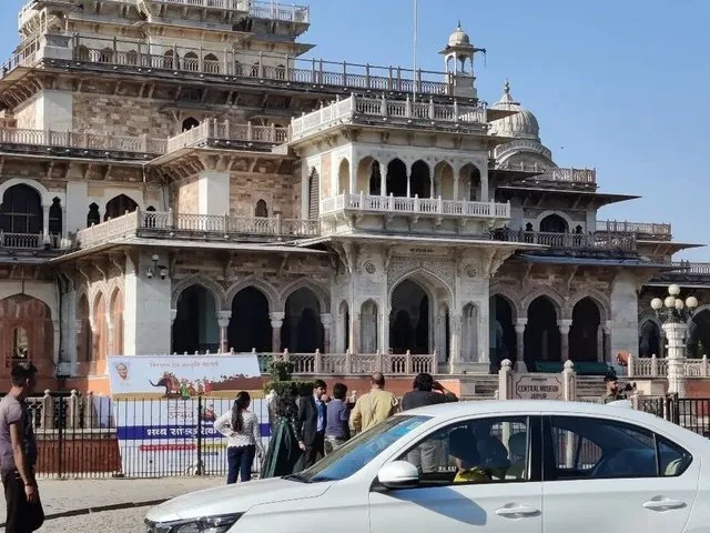 A white car parked in front of Albert Hall Museum.
