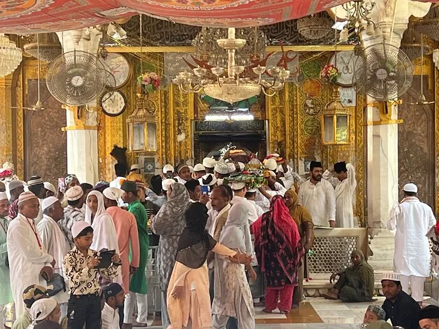 A crowded interior of a religious place with ornate decorations.