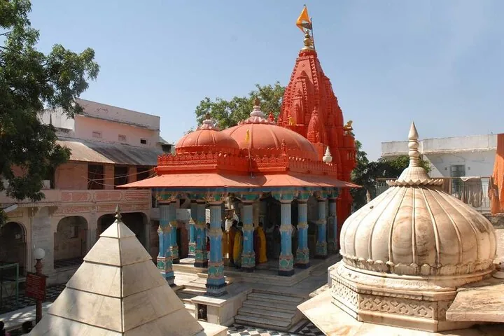 A red-orange temple with multiple domes and pillars.